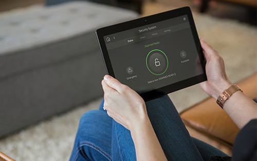 Young woman using smart home security access control system on her tablet.
